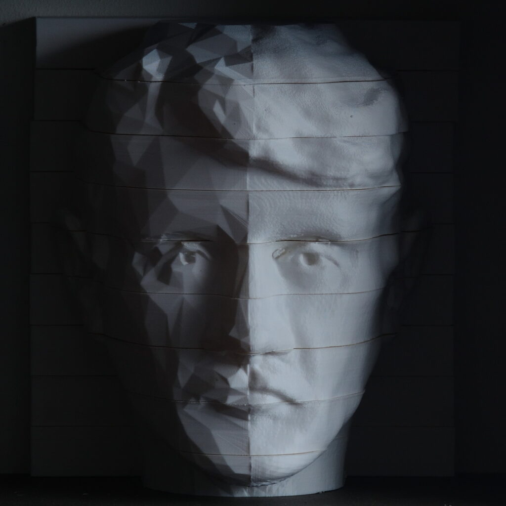 A 3d printed head of a man in a dark room.