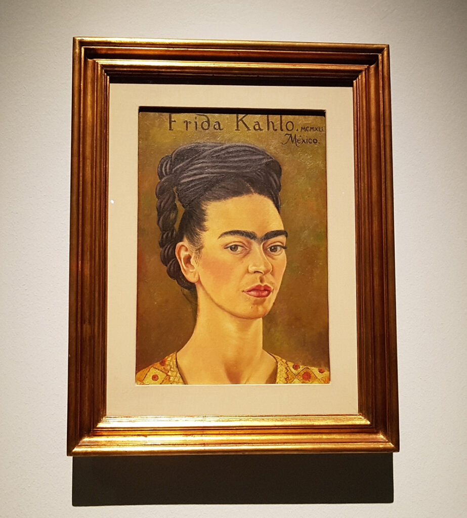 A painting of frida kahlo hanging on a wall.