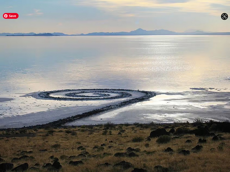 A spiral made of sand on the shore of a lake.