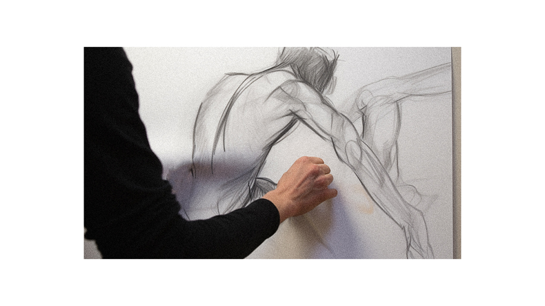 A person drawing a figure on a white board.