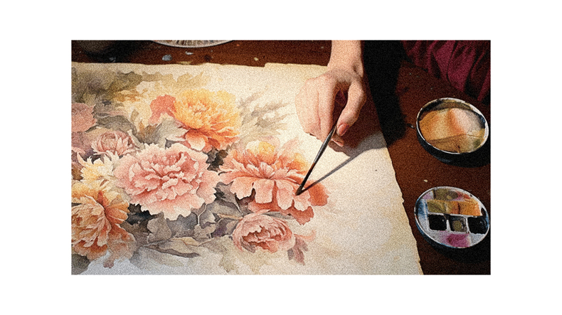 A woman is painting flowers on a piece of paper.
