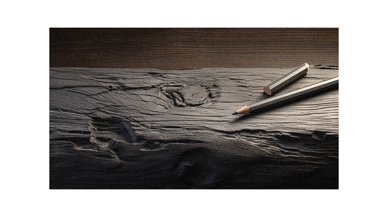 A pencil sits on top of a piece of wood.