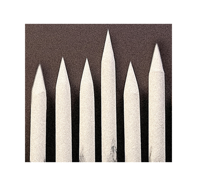 A row of white pencils on a brown surface.