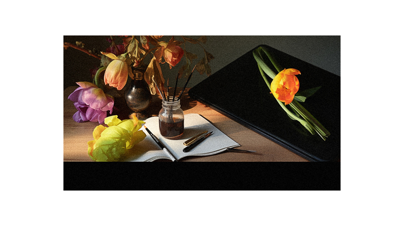 A vase of flowers and a notebook on a table.