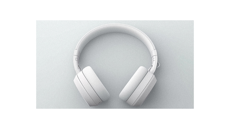 A pair of white headphones on a white surface.
