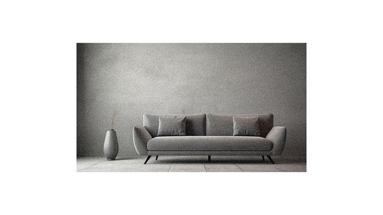 A grey sofa in front of a gray wall.