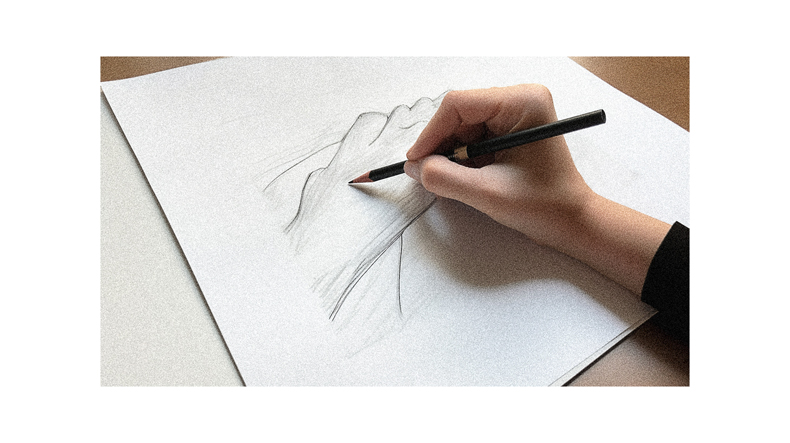 A person drawing a hand on a piece of paper.