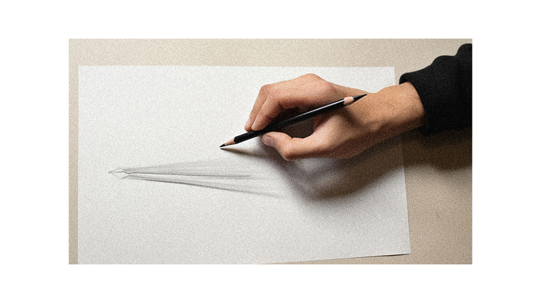 A person drawing a pencil on a piece of paper.